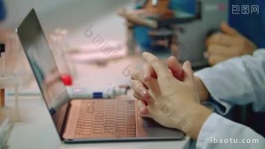 科学家手在笔记本电脑键盘上打字。女医生手打字笔记本电脑